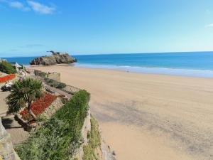 a beach with a retaining wall and the ocean at The Studio in Tenby