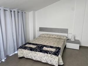 1 dormitorio con 1 cama con manta blanca y negra en Ample house w/ Views in front of Baells reservoir, en Sant Jordi de Cercs