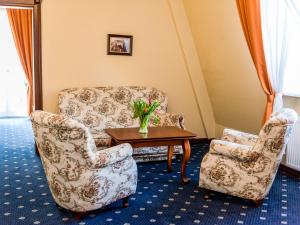 dwa krzesła i stół z wazonem kwiatów w obiekcie Pałac Godętowo w mieście Łęzyce