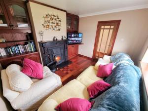 sala de estar con 2 sofás y chimenea en 3 Bed Renovated Cottage Carramore Lake, Belmullet en Ballina