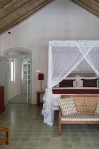 a bedroom with a bed with a canopy at Halcyon Mawella in Tangalle