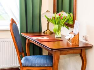 biurko z lustrem i wazonem kwiatów w obiekcie Pałac Godętowo w mieście Łęzyce