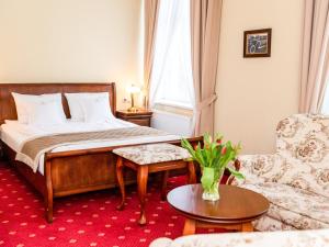sypialnia z łóżkiem, kanapą i krzesłem w obiekcie Pałac Godętowo w mieście Łęzyce