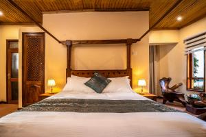 a bedroom with a large bed and two lamps at Divine Resort & Spa in Kampala