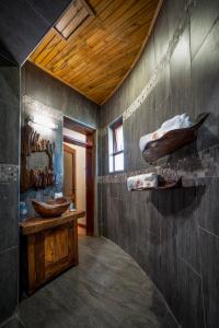 a bathroom with two sinks and a wooden ceiling at Divine Resort & Spa in Kampala