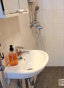a white sink in a bathroom with a shower at Siisti ja kodikas asunnon keskustassa+free parking in Kuopio