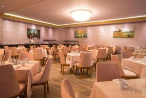 a dining room with white tables and chairs at Wyndham Batumi in Batumi