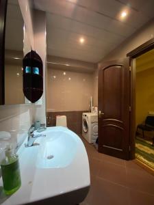 La salle de bains est pourvue d'un lavabo blanc et d'un miroir. dans l'établissement appartments in Batumi, à Batoumi