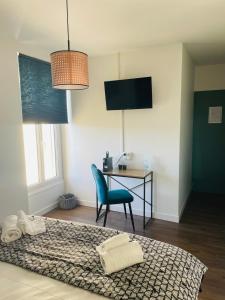 a bedroom with a bed and a desk and a chair at logis Paul Massy in Meschers-sur-Gironde