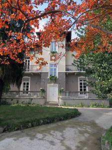 una casa bianca con una porta bianca e foglie rosse di Villa Crochat a Como