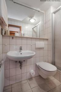 ein weißes Bad mit einem Waschbecken und einem WC in der Unterkunft Hotel Meeresburg in Norderney