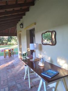 Habitación con mesa, lámpara y espejo. en La Perdida Casa de Campo en San Antonio de Areco