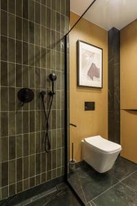uma casa de banho com um chuveiro e um WC. em Sunnyway Apartment em Ustronie Morskie