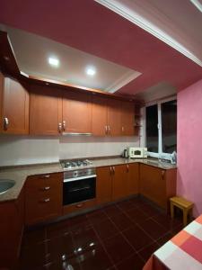 a kitchen with wooden cabinets and a stove top oven at appartments in Batumi in Batumi