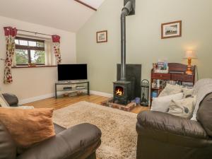 uma sala de estar com um sofá e uma lareira em The Barn em North Burton