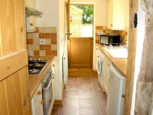 a kitchen with a sink and a stove top oven at Point Cottage in Blakemere