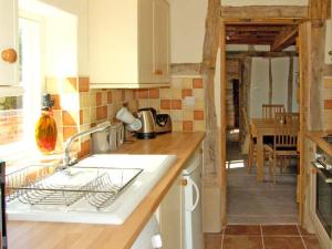 a kitchen with a sink and a counter top at Point Cottage in Blakemere