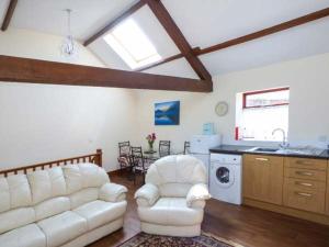 a living room with two white couches and a kitchen at Surprise View in Holmrook