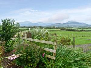 a wooden fence in a field with mountains in the background at Surprise View in Holmrook