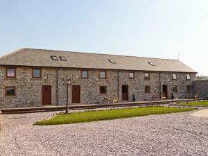 un gran edificio de piedra con puertas y ventanas. en Beudy Bach en Abergele