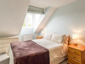 a bedroom with a large bed and a window at Old Hall Cottage in Greenhaugh