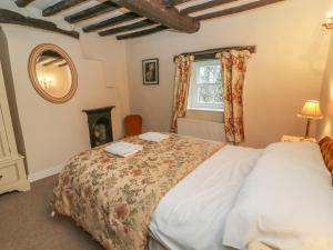 a bedroom with a bed and a window at Beckside Cottage in Mansergh