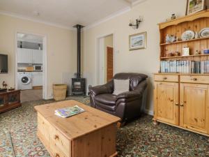 ein Wohnzimmer mit einem Ledersessel und einem Couchtisch in der Unterkunft The Bungalow in Ipswich
