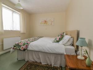 Schlafzimmer mit einem Bett, einem Tisch und einem Fenster in der Unterkunft The Bungalow in Ipswich