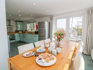 a kitchen and dining room with a table with food on it at Scott's Cottage in Helston