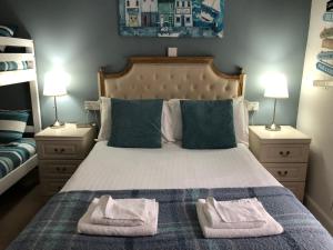 a bedroom with a bed with two towels on it at Bella Vista Hotel in Weston-super-Mare