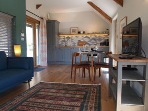 a living room with a table and a blue couch at Bruckton Stables Annex in Dartmouth