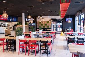 restauracja z czerwonymi krzesłami i stołami w restauracji w obiekcie Hotel Picaro Żarska Wieś Południe A4 kierunek Polska w mieście Zgorzelec
