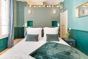 a bedroom with a large white bed and blue walls at The Charming Trocadero Eiffel Tower in Paris