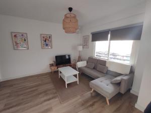 ein Wohnzimmer mit einem Sofa und einem Tisch in der Unterkunft Apartamento en primera línea de playa A - Marbella Centro in Marbella