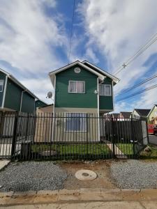 a green house behind a fence at Casa Bilbao Villarrica in Villarrica