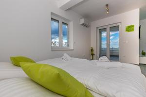 a bedroom with two large white beds with green pillows at Sun Villa in Dramalj +71 photos