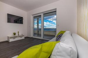 a living room with a white couch and a large window at Sun Villa in Dramalj