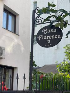 un panneau devant un bâtiment avec une clôture dans l'établissement Casa Florescu 13, à Bucarest