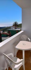 因赫尼奧的住宿－Holla del Saldo，阳台配有白色的桌椅