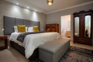 a large bedroom with a large bed with yellow pillows at Longhill Lodge in Addo