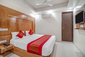 a bedroom with a large bed and a television at Hotel Classic Paradise Inn in New Delhi