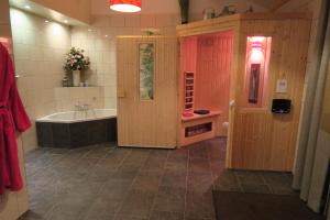 ein Badezimmer mit einer Badewanne, einem Waschbecken und einer Badewanne in der Unterkunft Aldörrum Hoevelogementen in Aarle-Rixtel