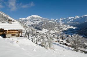 una ciudad en la nieve con montañas en el fondo en Studio Danay, en Le Grand-Bornand