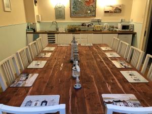 a long wooden table with chairs and a kitchen at Bella Vista Hotel in Weston-super-Mare