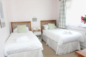 1 dormitorio con 2 camas y ventana en 15 Churchfields - Bungalow with Estuary Views and Parking en Dartmouth