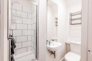 a white bathroom with a toilet and a sink at Modern 2 Bedroom Queen Street Apartment in Norwich