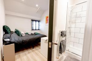 a bedroom with a bed and a shower in a room at Modern 2 Bedroom Queen Street Apartment in Norwich