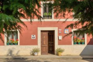 een rood gebouw met een deur en bloemen in ramen bij Albergue LaMorena in Ledigos