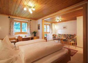 a bedroom with two beds and a table and a couch at Hotel Montabella in Schruns