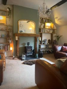 a living room with a fireplace and a mirror at Mingo Cottage in Bewdley